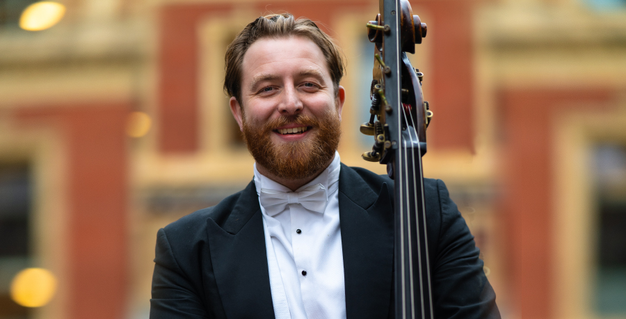 RPO Player David FC Johnson holding his double bass and smiling at the camera