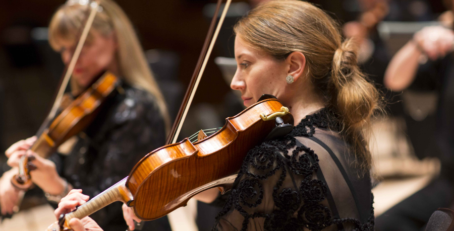 RPO Player Charlotte Ansbergs playing the violin in concert.