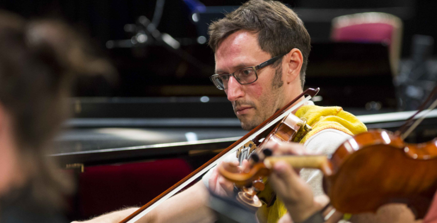 RPO Player Stephen Payne playing the violin in rehearsal.