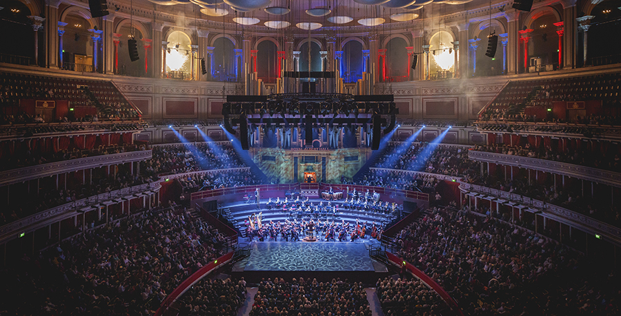 An image showing the Royal Albert Hall's auditorium, with a huge Organ behind the stage, an orchestra in front of it, and a flat stage for ballet dancing in front of the Orchestra.