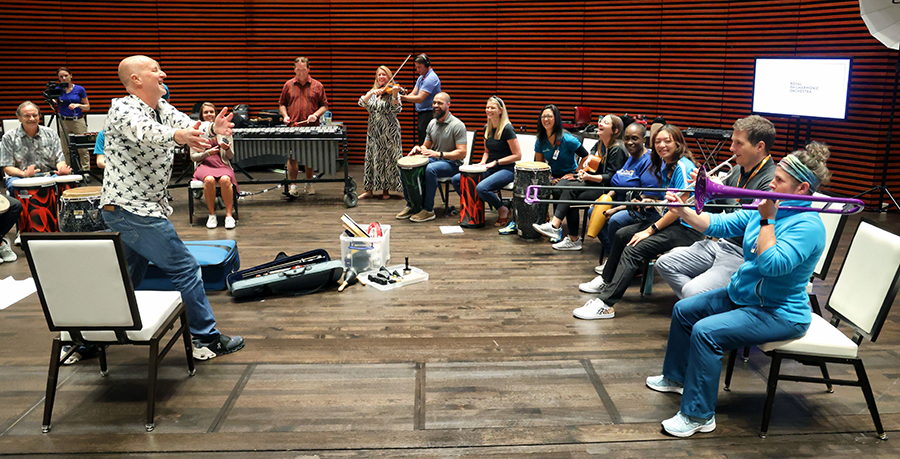 An image of a man conducting a group of musicians 