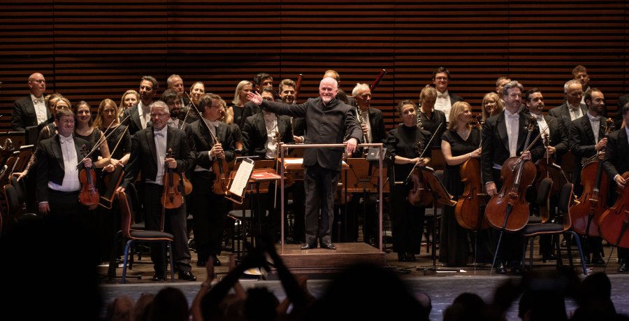 Conductor Paul Murphy and the Royal Philharmonic Orchestra standing to recieve applause on the stage of the Steinmetz Hall