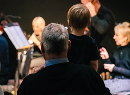 An older man with a young child watching an RPO performance