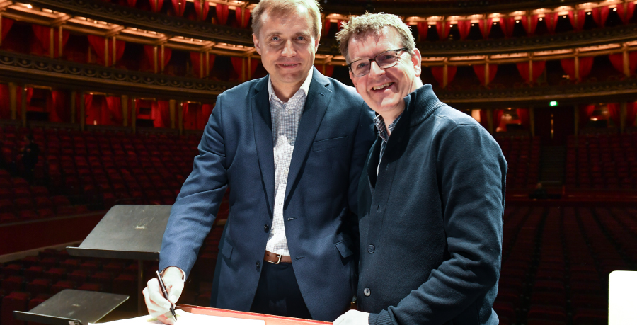 Vasily Petrenko on the Royal Albert Hall podium with RPO chair Andrew Storey smiling and signing a document
