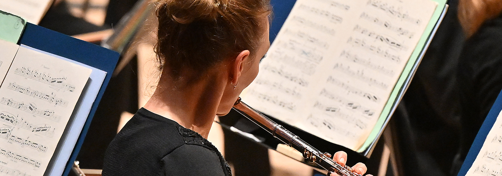 The Royal Philharmonic Orchestra performing at the Southbank Centre in London. Image shows a female flutist performing in front of open sheet music Credit: Mark Allan