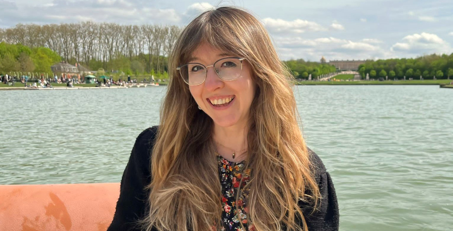 Holly Isherwood standing by a lake and smiling