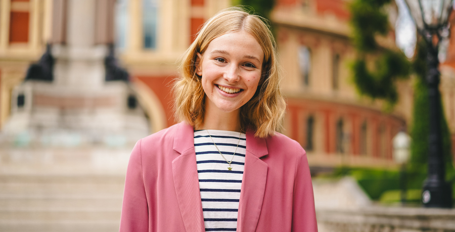 Minnie Elliott in a striped shirt and pink blazer outside the Royal Albert Hall