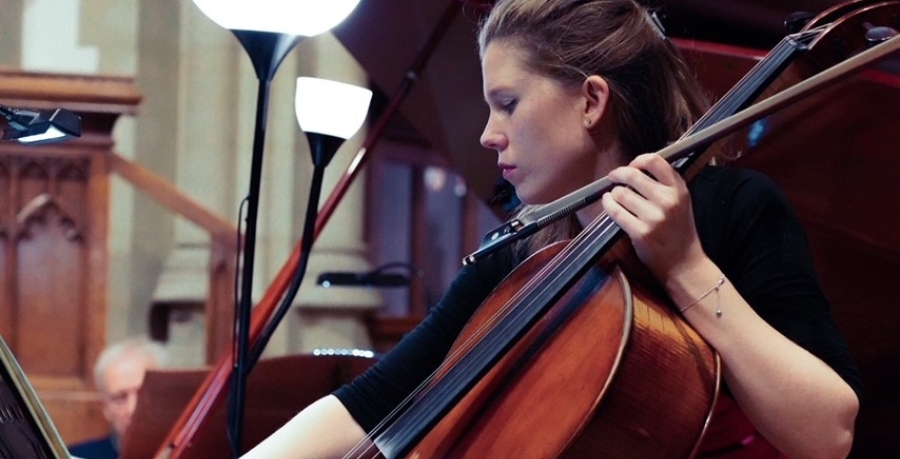 Naomi Watts playing the cello in a church