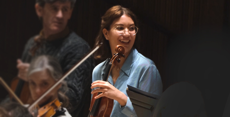 RPO Player Adriana lacovache-Pana smiling as she plays the violin.