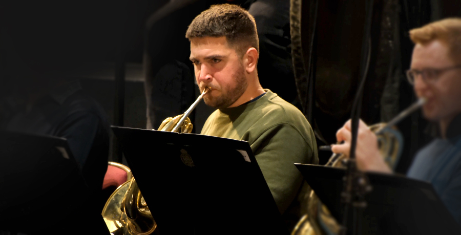 RPO Player Ben Hulme playing the horn in rehearsal.