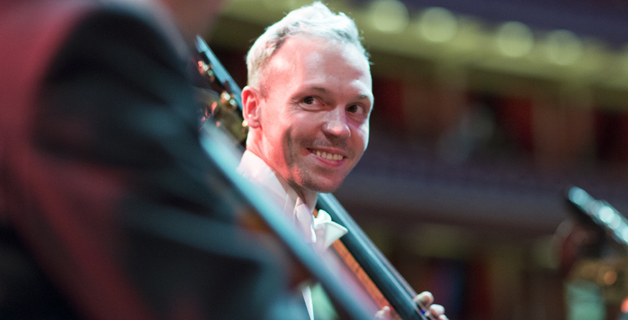 RPO Player Benjamin Cunningham smiling whilst holding his double bass.