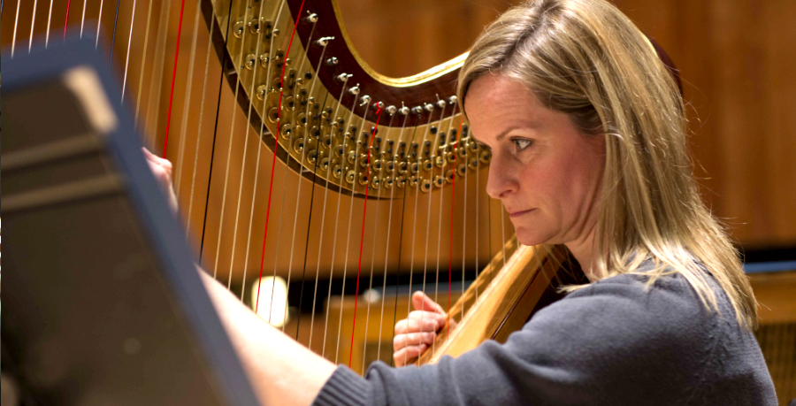 RPO Player Suzy Willison-Kawalec playing the harp in rehearsal.