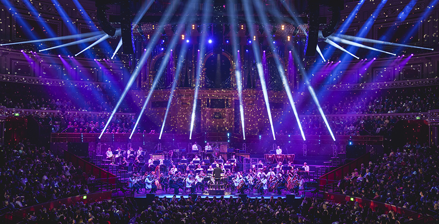 An photo showing the RPO on stage at the Royal Albert Hall. White lights emit from the stage and you can see the Hall's organ in the background
