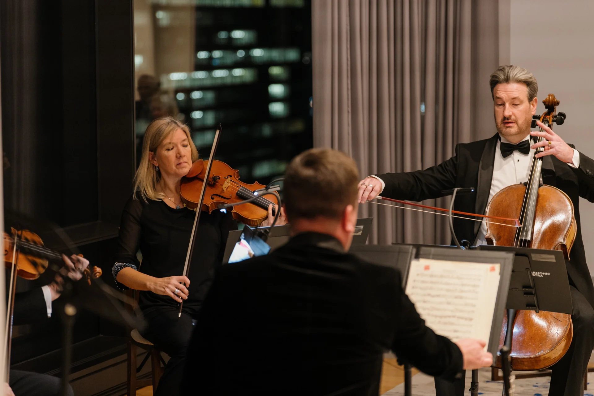 RPO mixed chamber ensemble performing at the British Consulate New York with a background of the New York skyline.