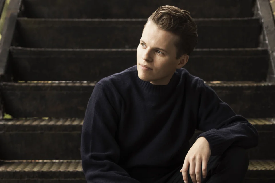 Adam Hickox sitting on steps and looking to the side
