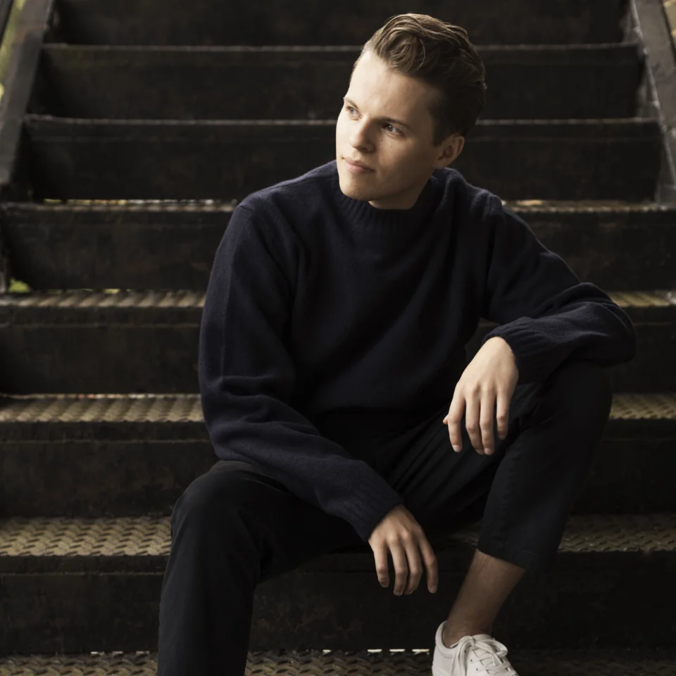 Adam Hickox sitting on steps and looking to the side