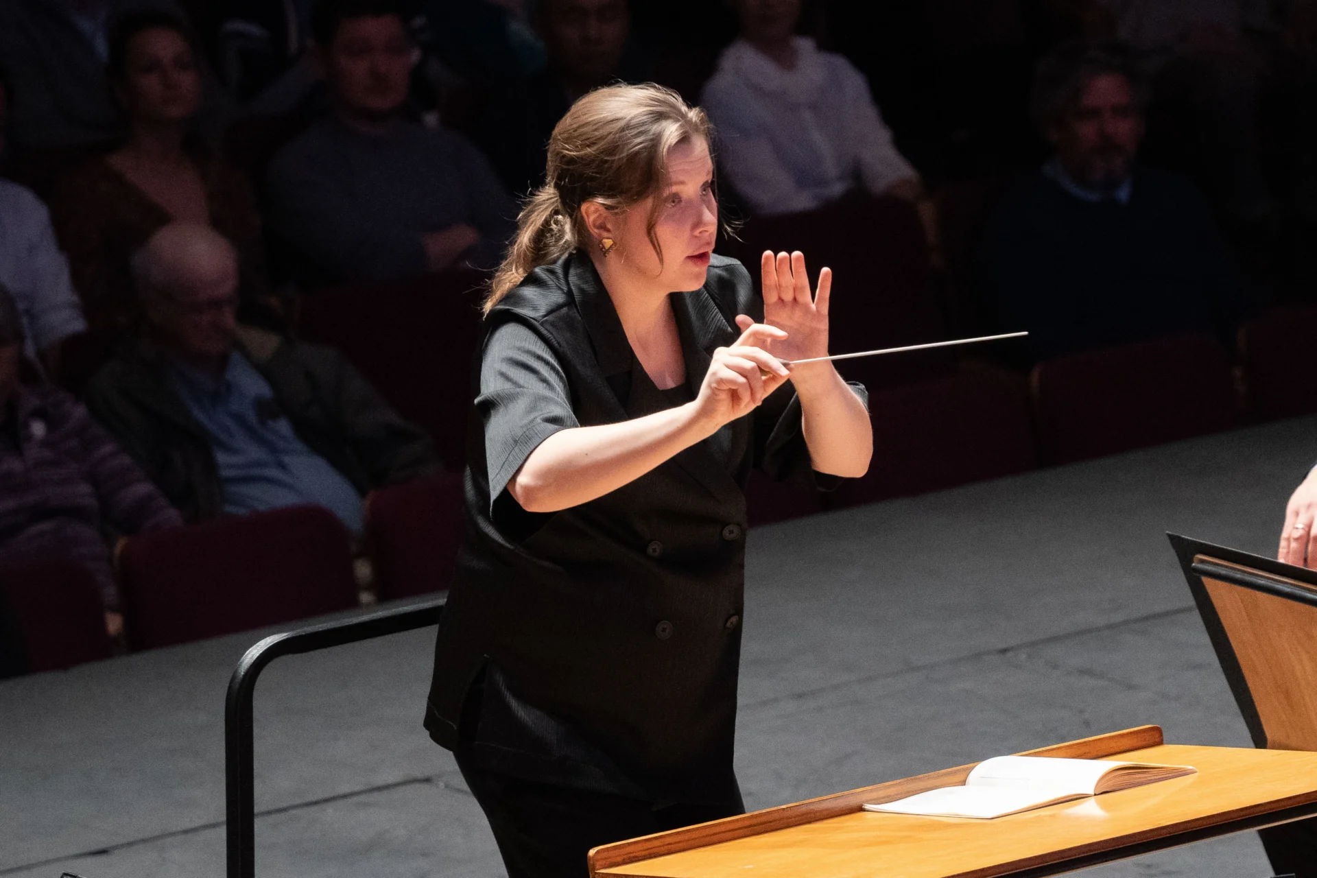 Conductor Emilia Hoving stands in concert, with baton in hand