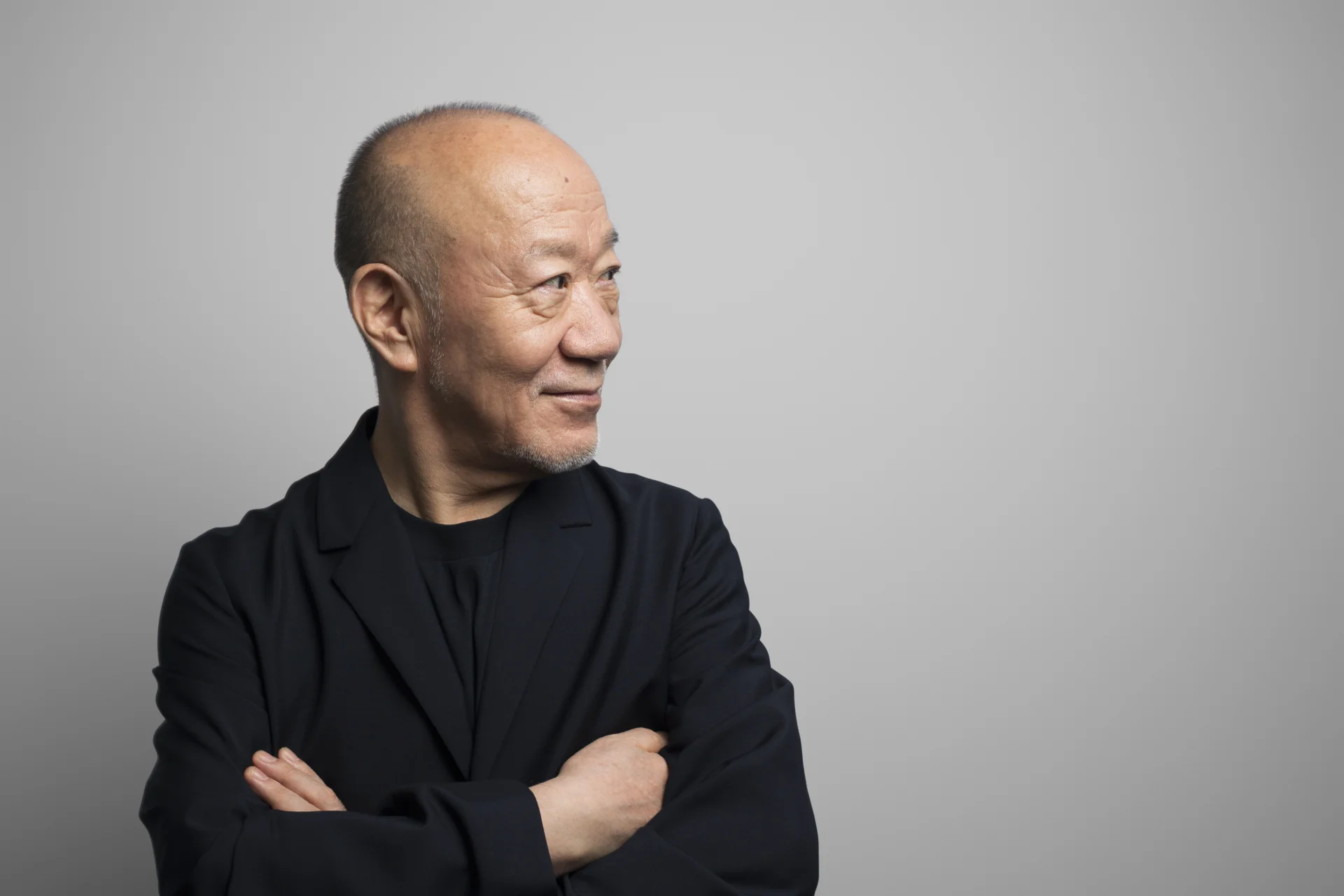 Joe Hisaishi looking to the side with arms folded