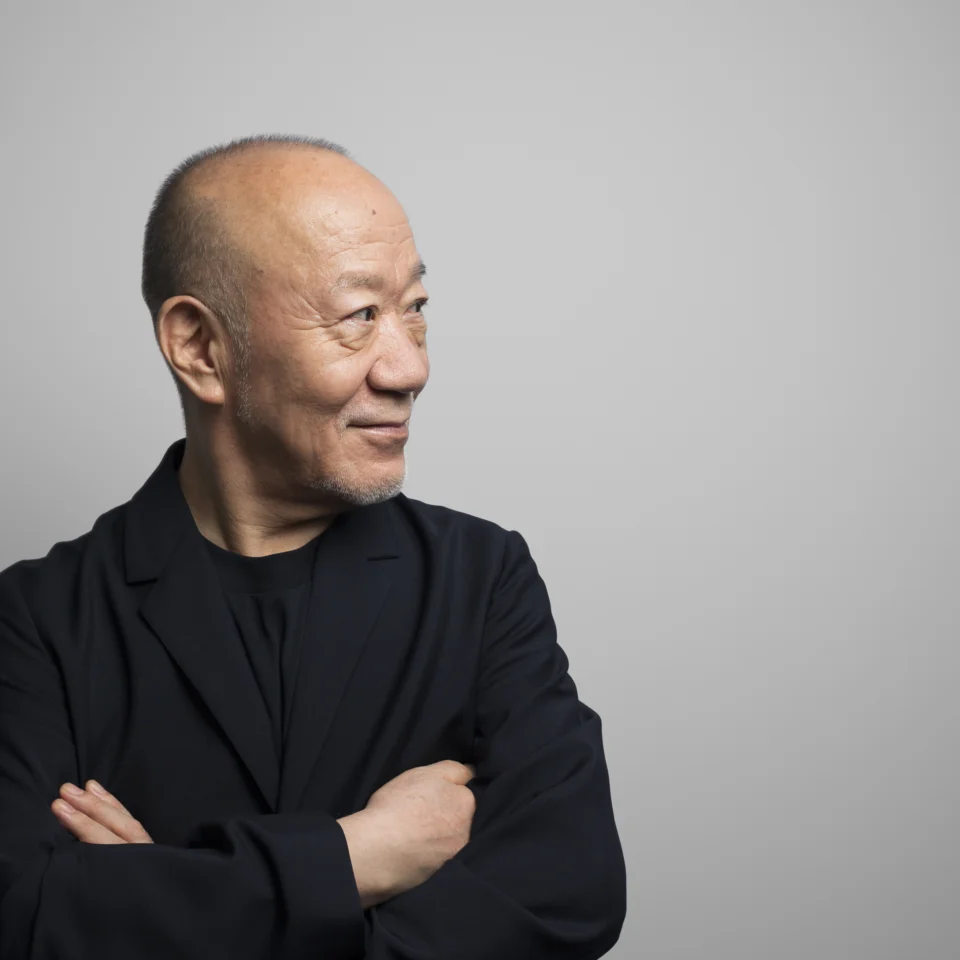 Joe Hisaishi looking to the side with arms folded