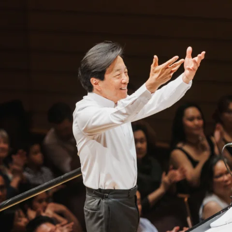 Mandle Cheung smiling as he conducts
