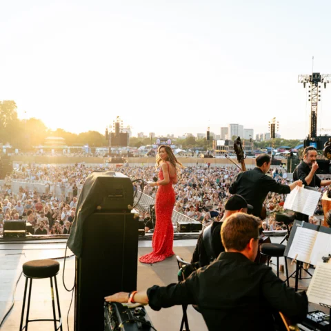 Myleene Klass in a red dress on stage with the Orchestra at BST Hyde Park