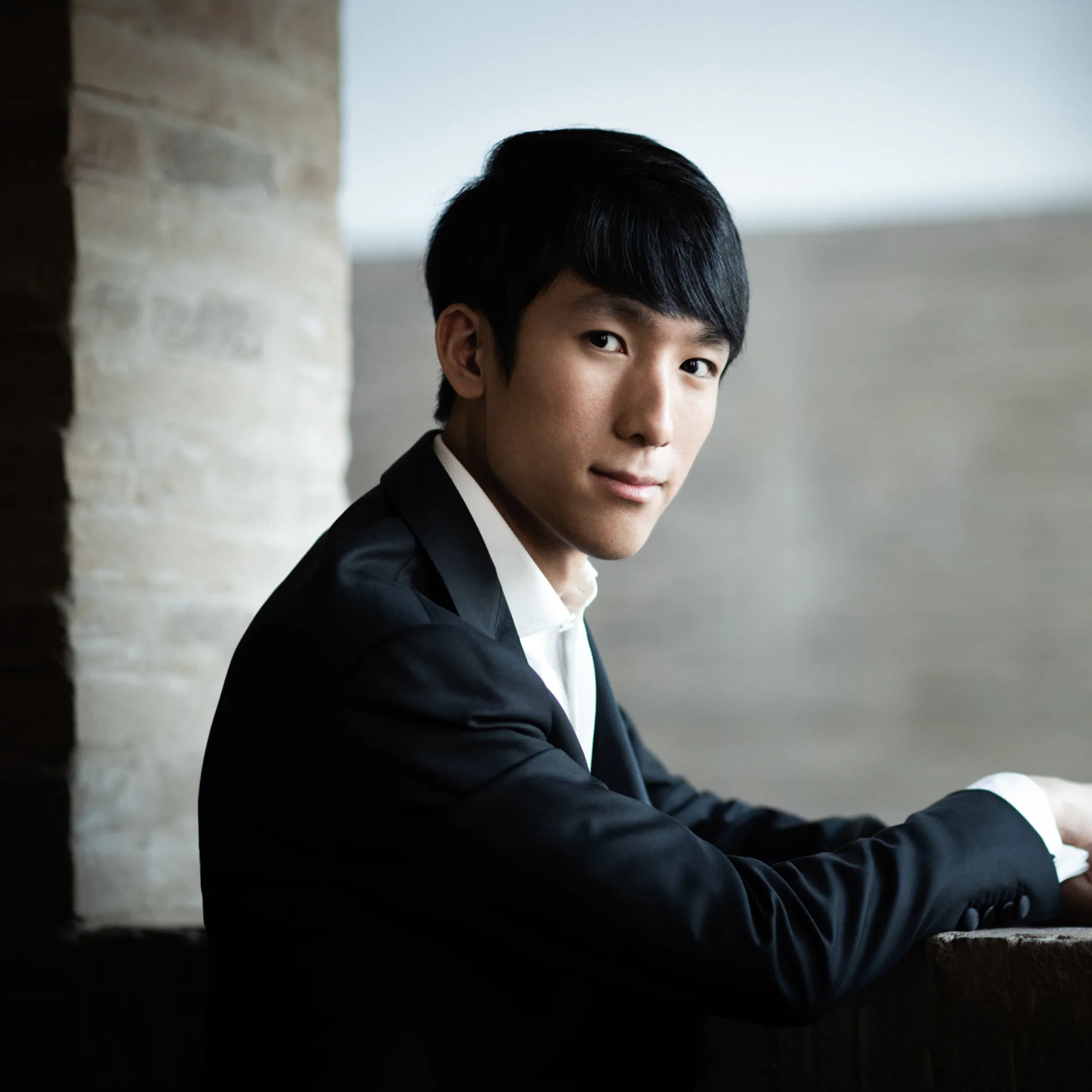 Eric Lu ina suit jacket and white shirt looking at the camera and smiling