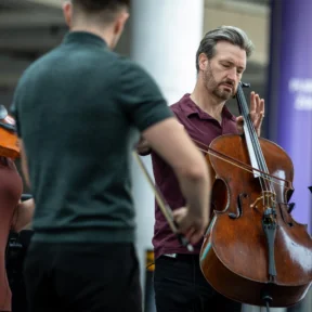 RPO string players performing underneath the steps by Wembley Stadium
