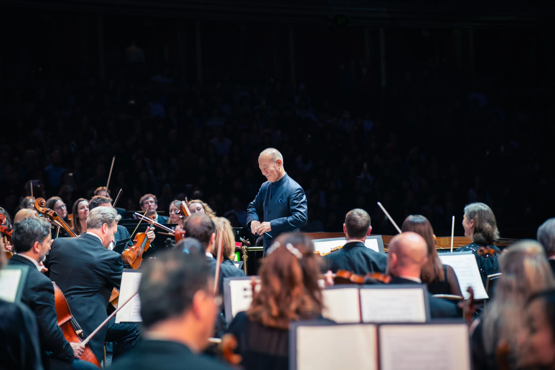 Joe Hisaishi smiling as he is about to conduct the Orchestra