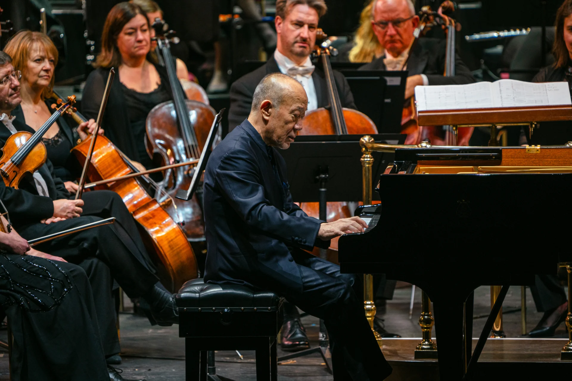 Joe Hisaishi playing the piano in front of the Orchestra