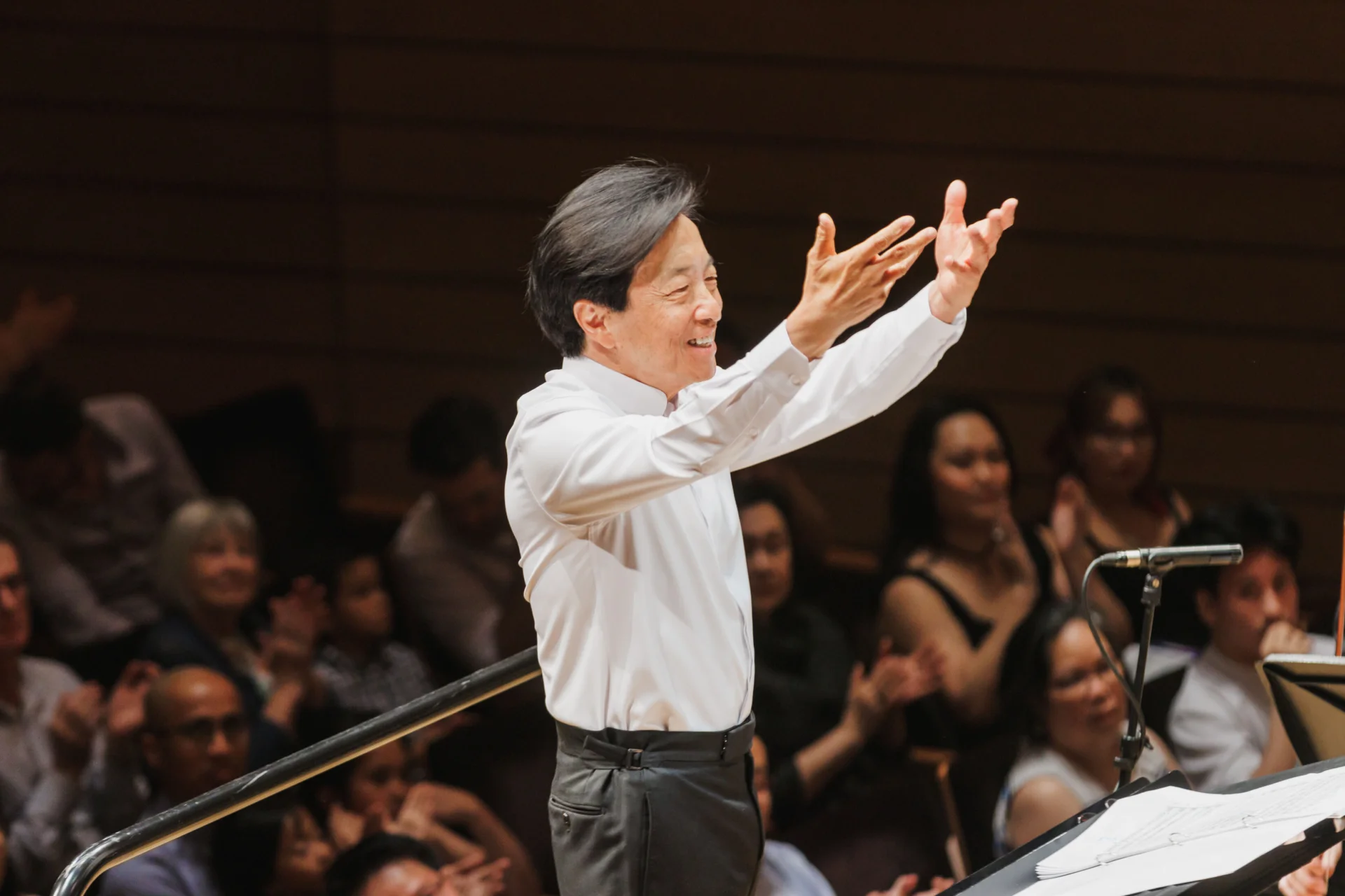 Mandle Cheung smiling as he conducts
