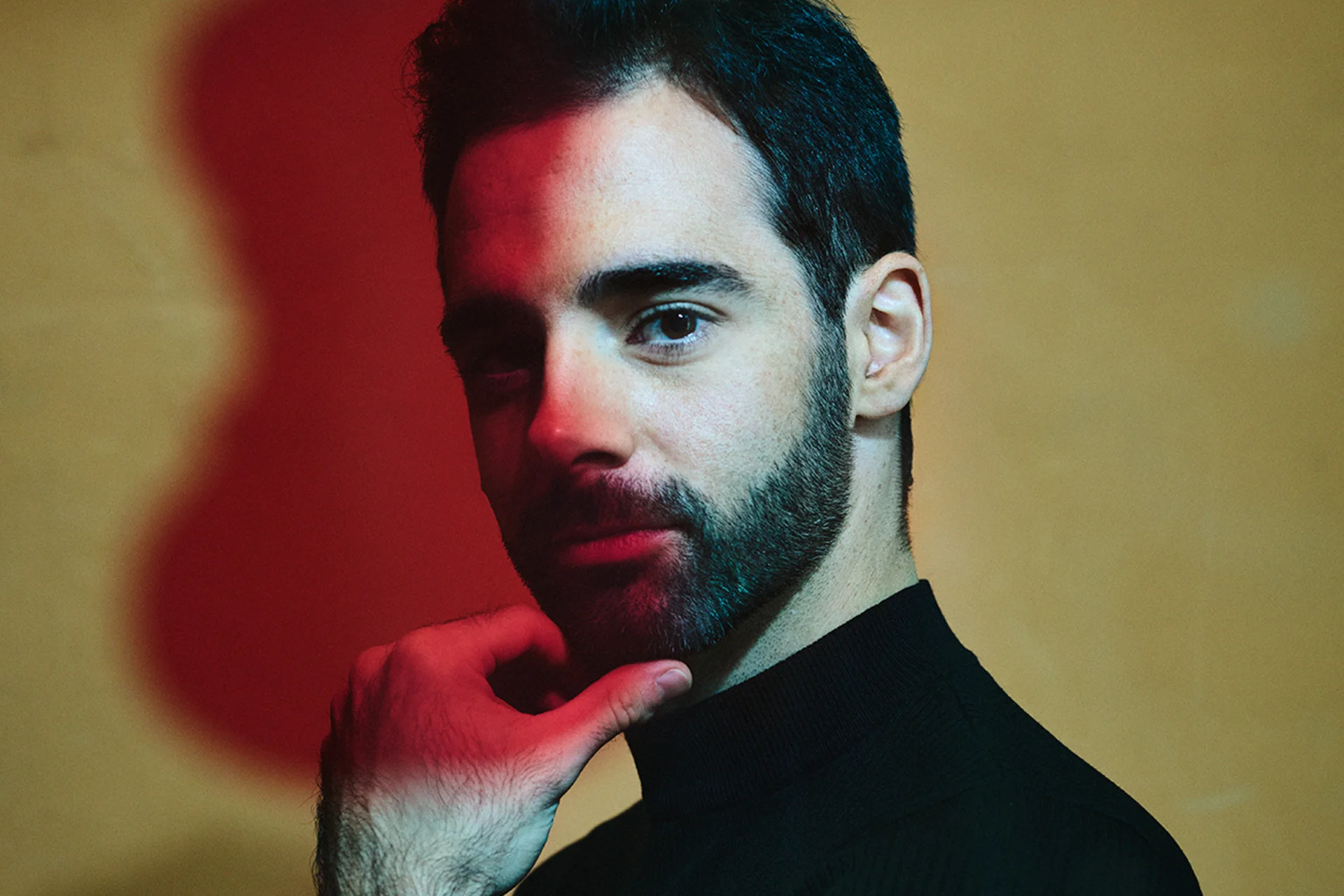 Cellist Pablo Ferrández scratching his chin and looking at the camera