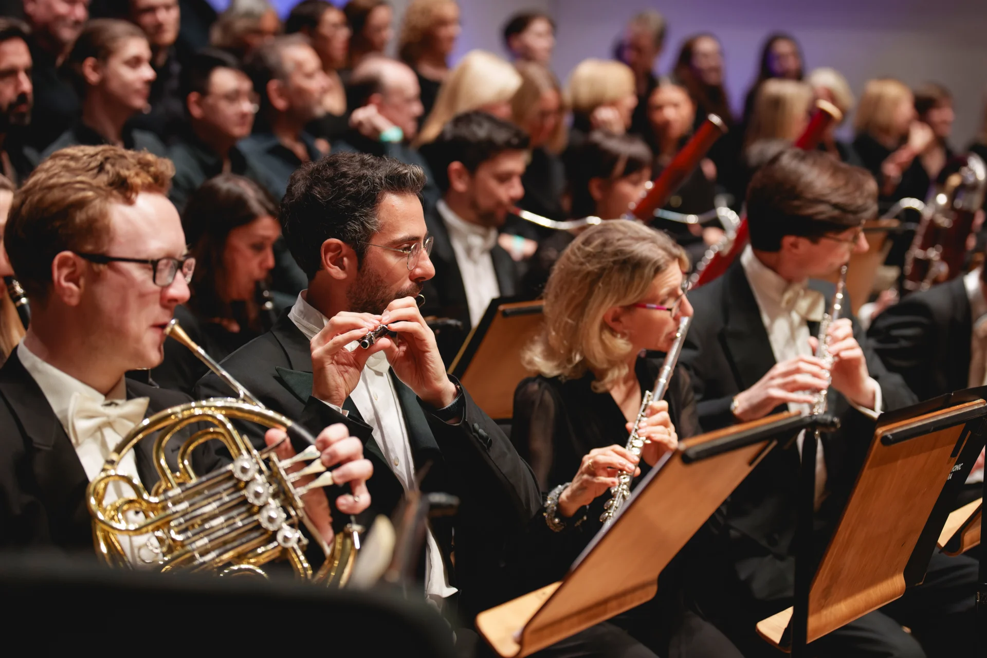 The RPo wind section playing in front of a choir at Cadogan Hall. The piccolo is in focus.