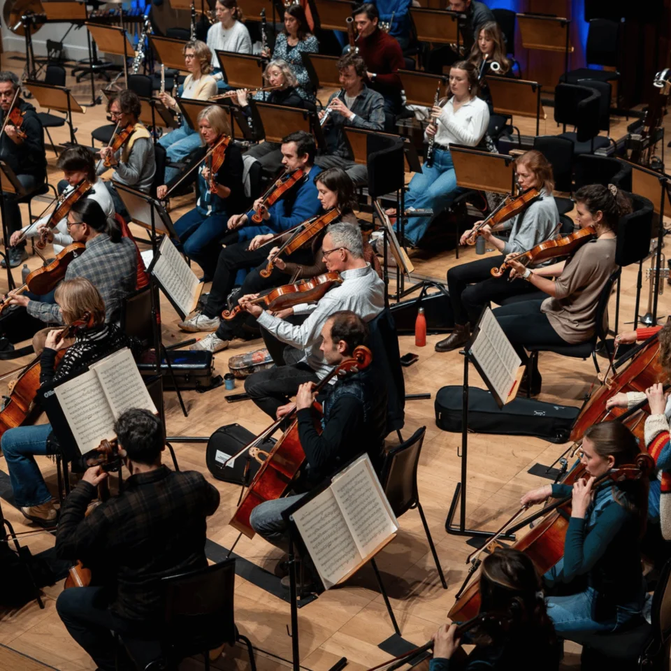 An overhead image of the string and wind section of the Royal Philharmonic Orchestra in rehearsal at Cadogan Hall