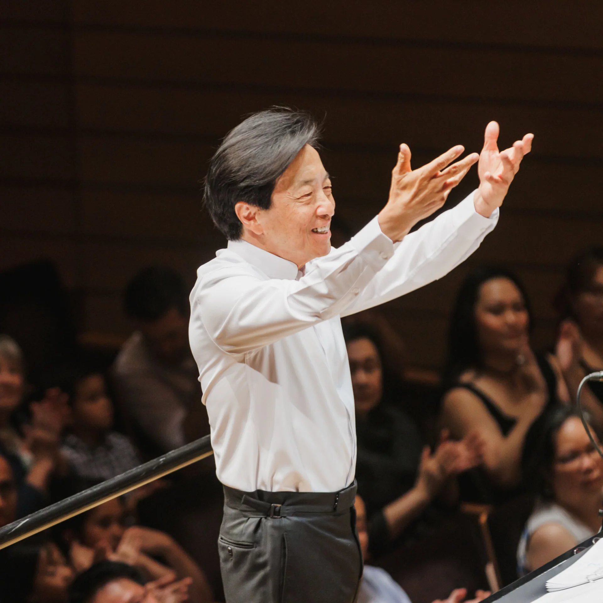 Mandle Cheung smiling as he conducts
