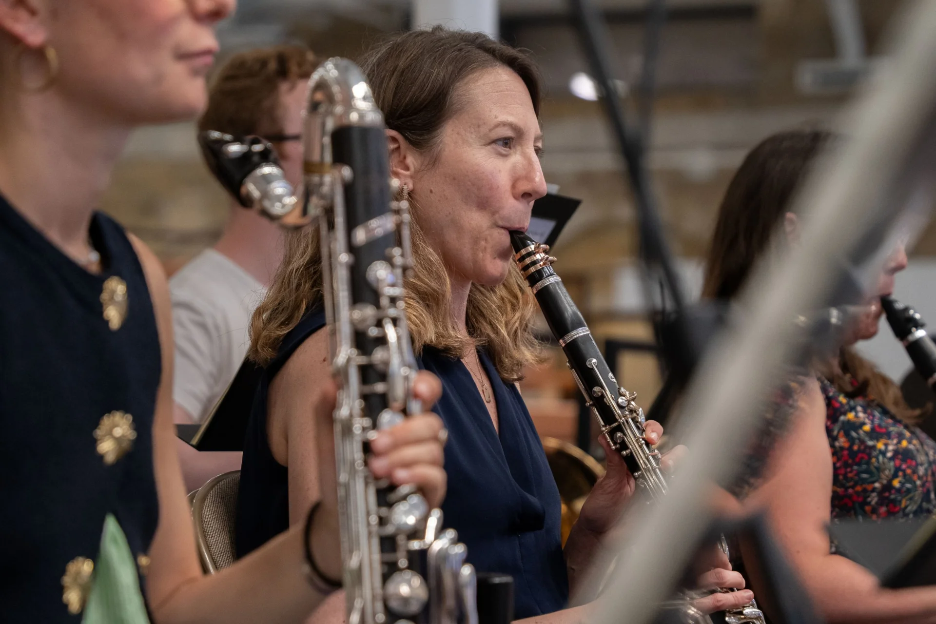 The woodwind section of the Royal Philharmonic Orchestra in rehearsal, smiling while playing
