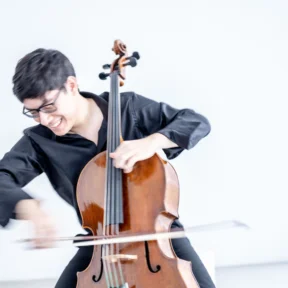 Zlatomir Fung plays his cello while smiling