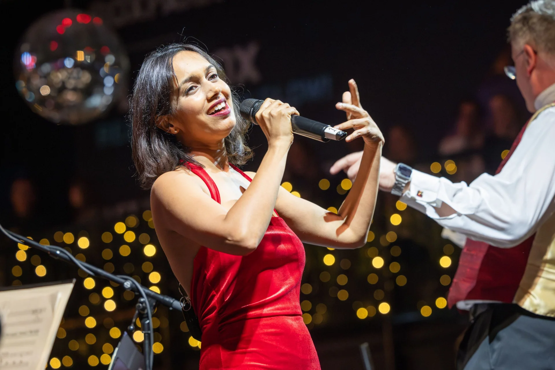 Sumudu Jayatilaka performing with the Royal Philharmonic Orchestra, singing with her arms outstretched
