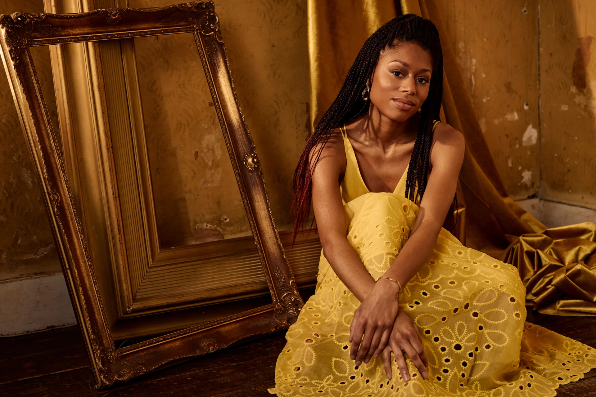 Isata Kanneh-Mason seated in yellow dress in front of empty gold mirror