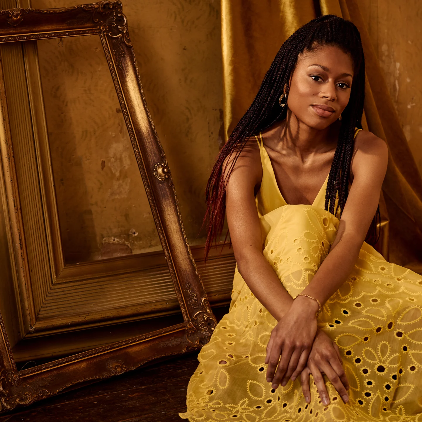 Isata Kanneh-Mason seated in yellow dress in front of empty gold mirror