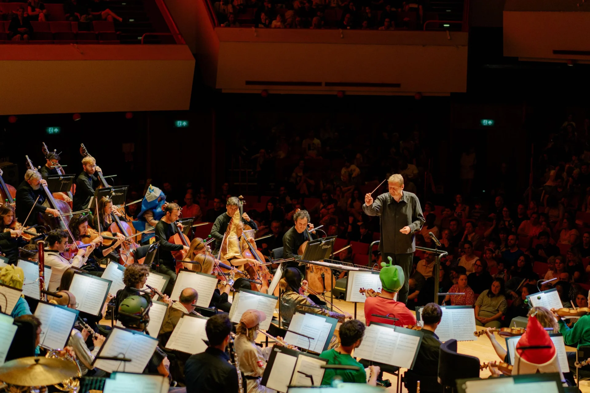 The Royal Philharmonic Orchestra performs a Noisy Kids concert, wearing various costumes on stage