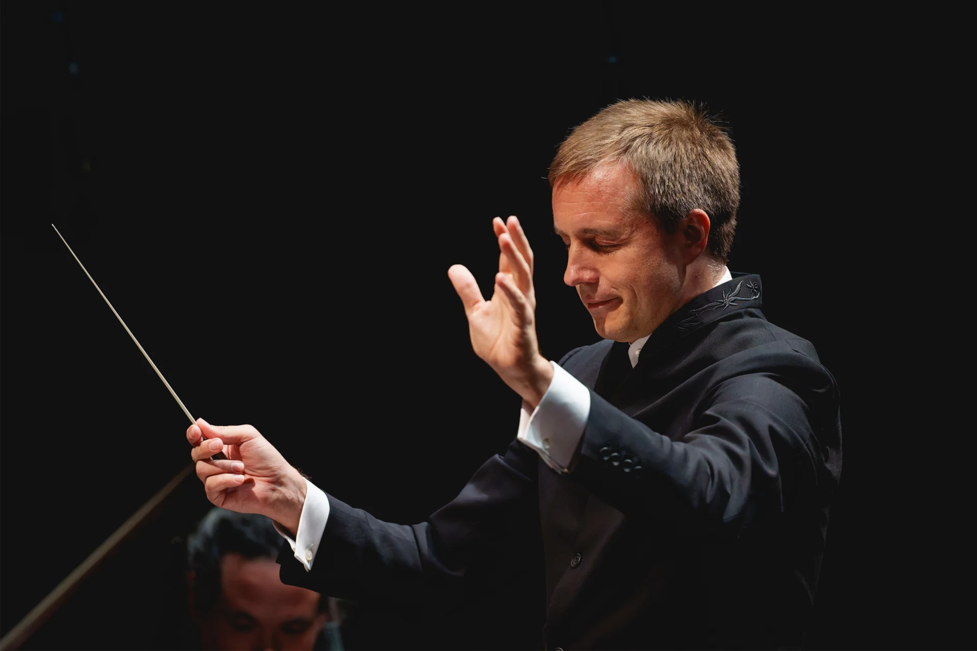 Vasily Petrenko conducting with his eyes closed and arms raised