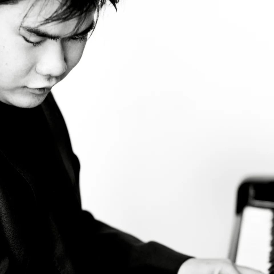 A black and white photo of Nobuyuki Tsujii playing the piano