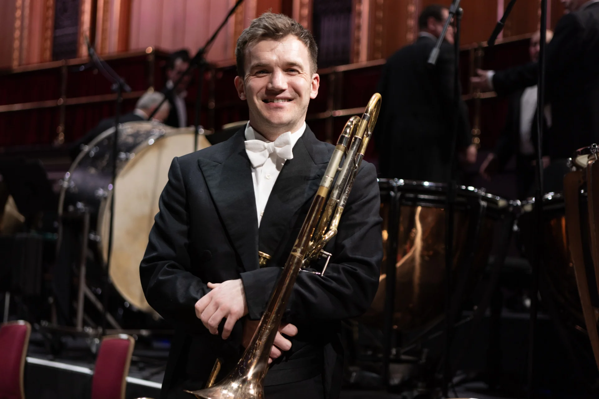 Tom Berry standing on stage with trombone