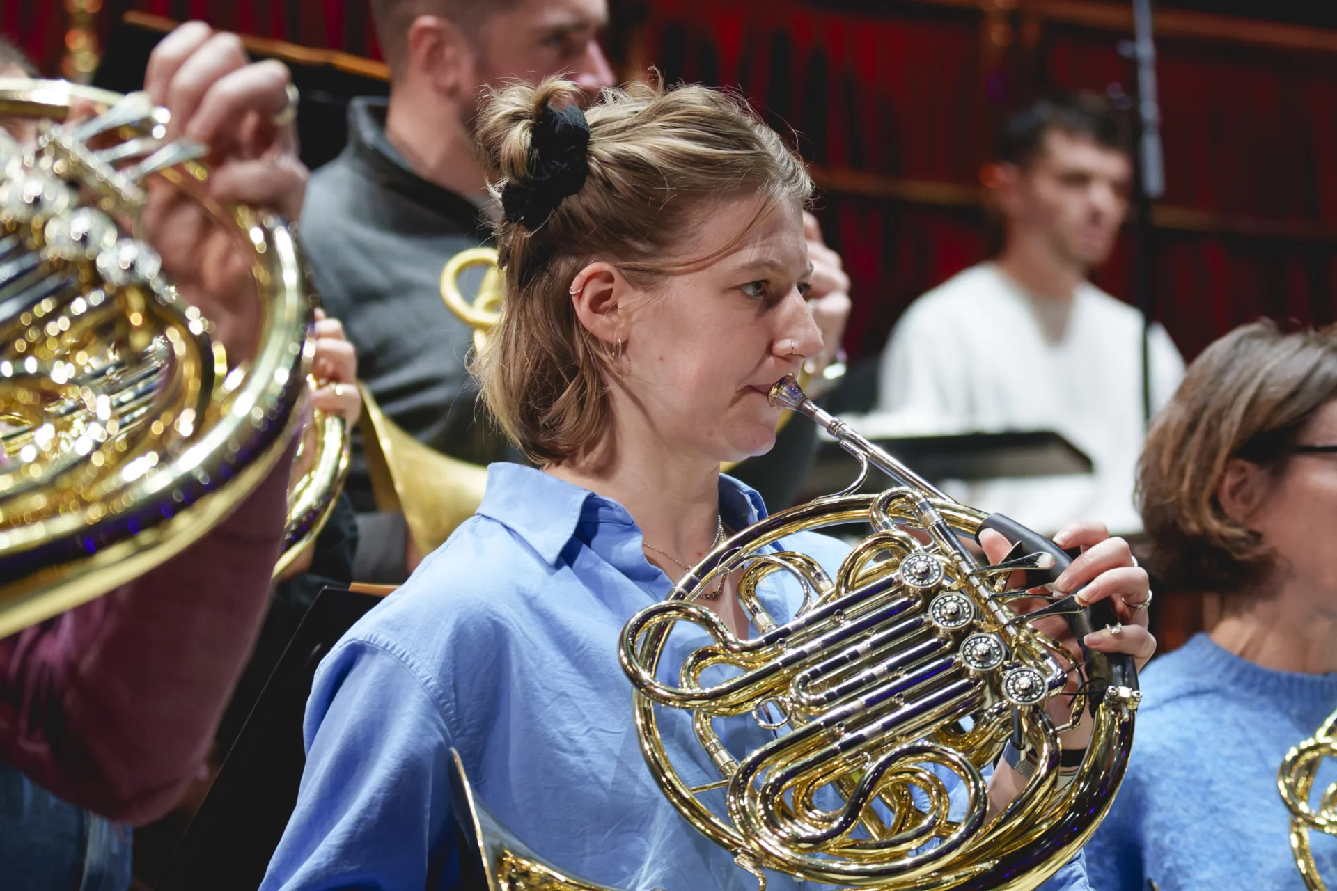 Zoë Tweed playing horn in rehearsal