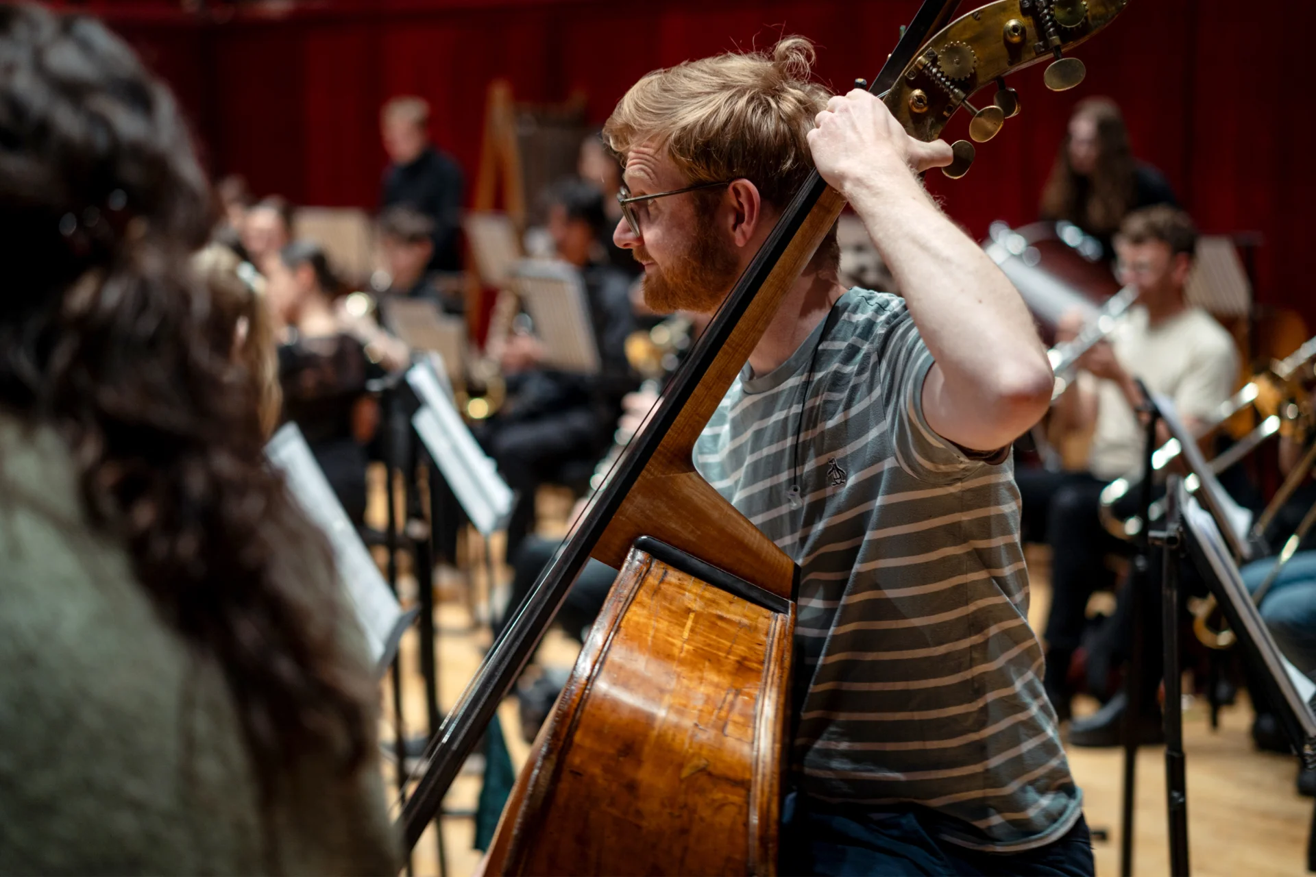 A side-on photo of double bass player Joe Cowie in rehearsal at Reading's Hexagon