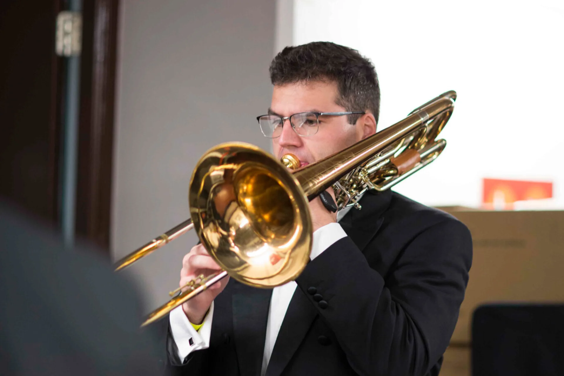 Josh Cirtina playing bass trombone backstage