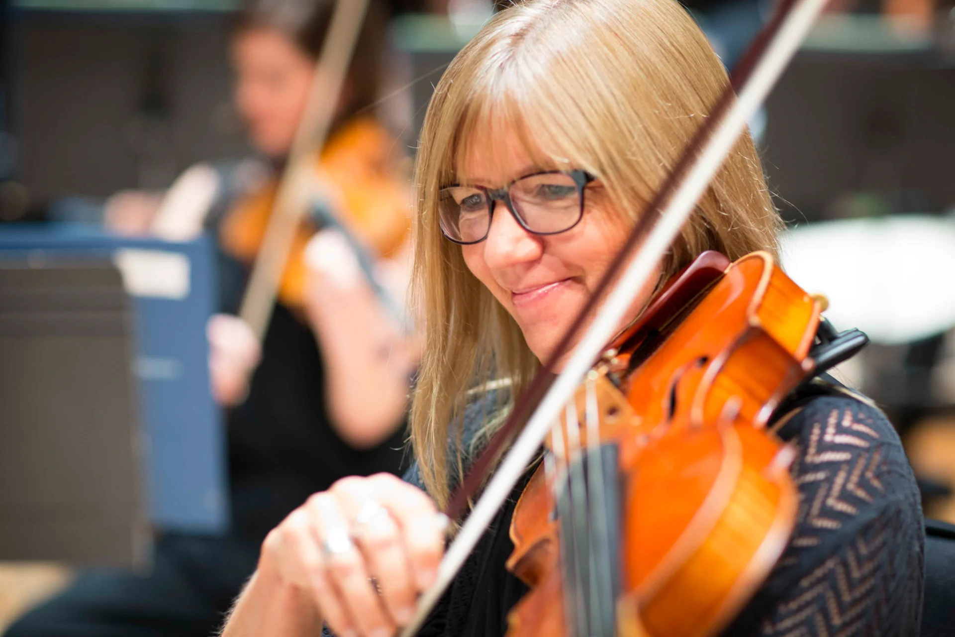 Liz Varlow smiling looking downwards holding viola