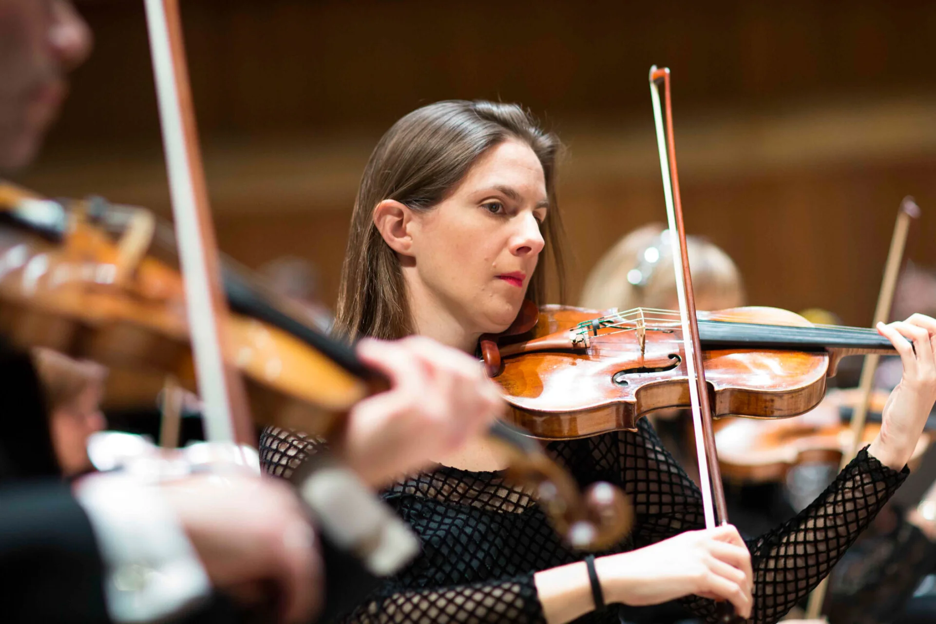 Shana Douglas playing the violin within the Orchestra