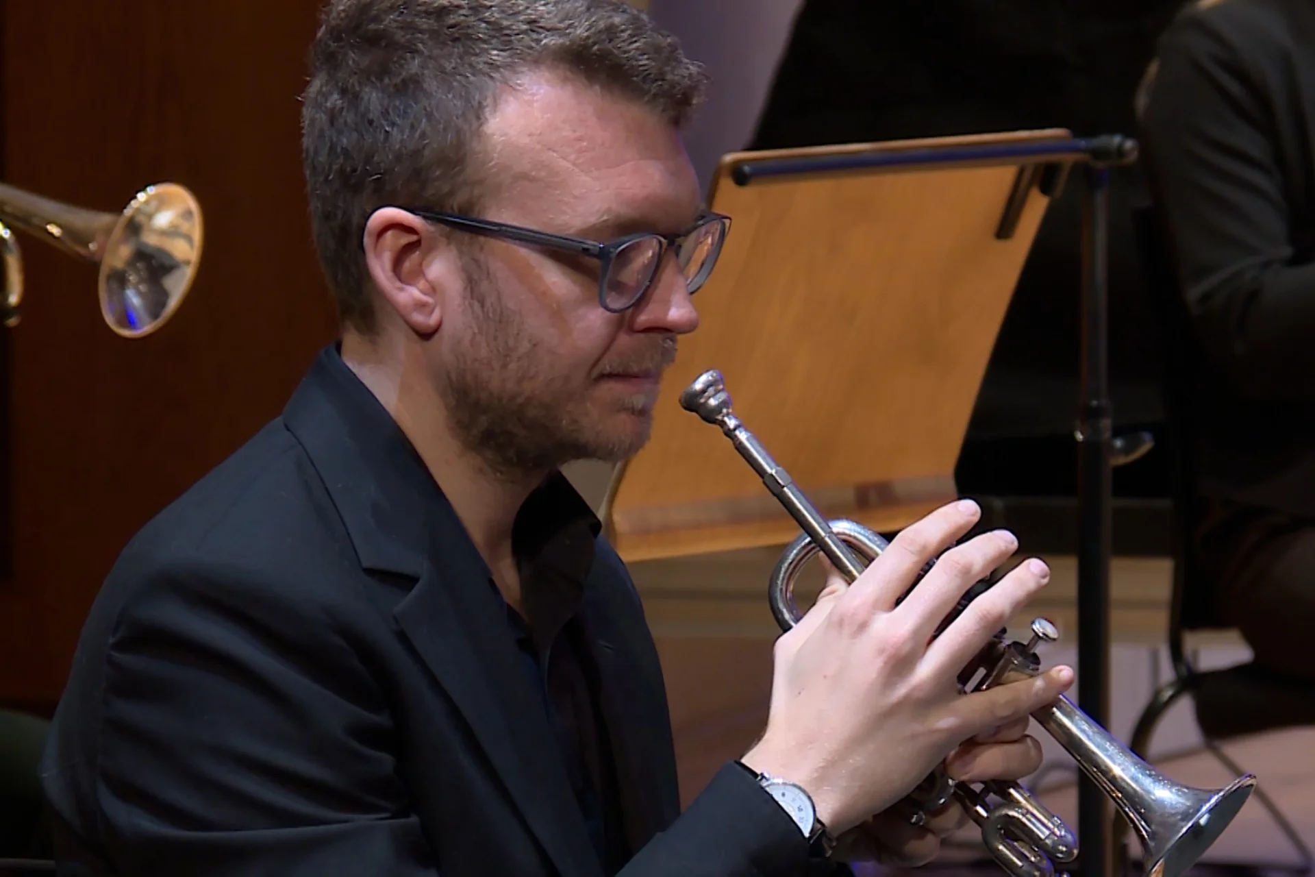 Toby Street sitting in black jacket with trumpet