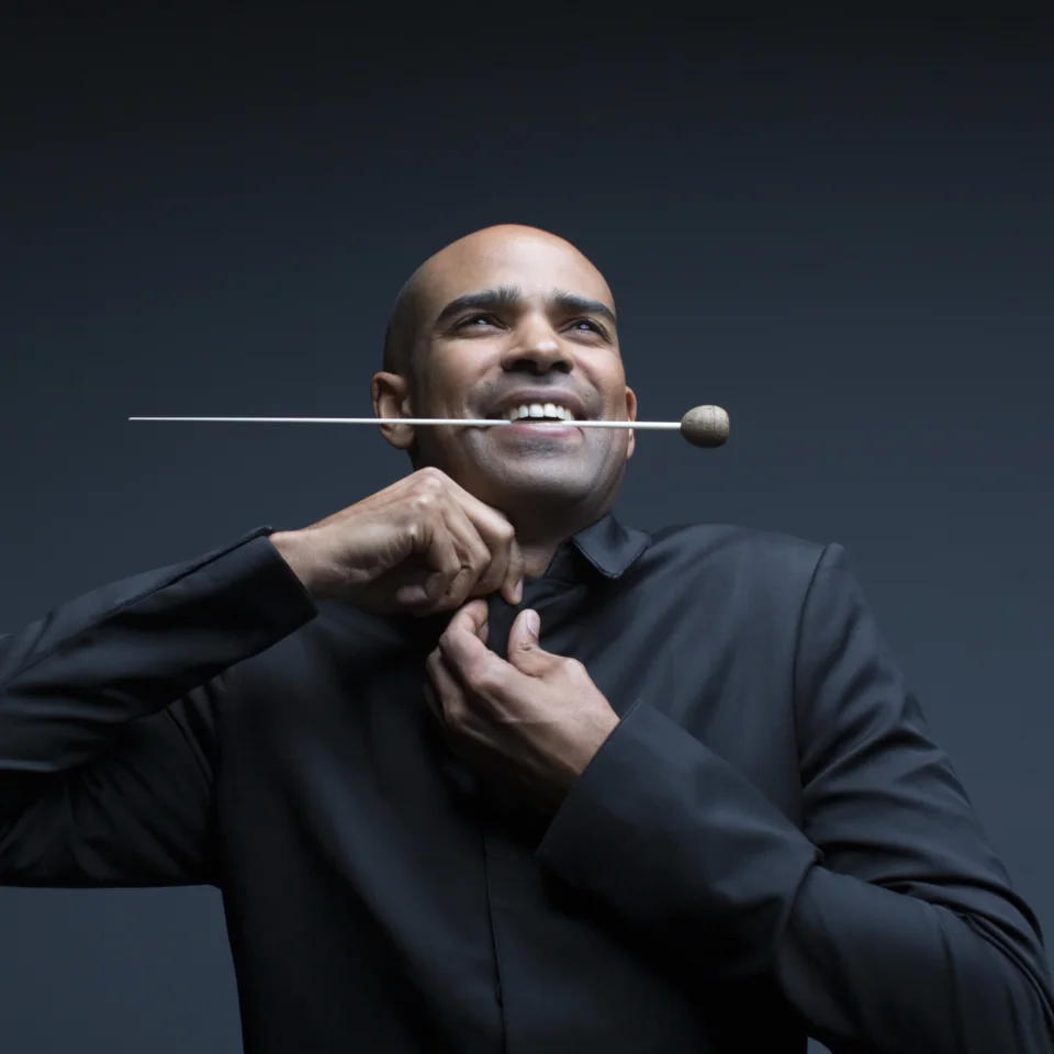 Kevin John Edusei doing up his tie with baton in mouth
